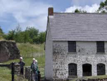 Stone building with a thatched roof at Blaenau Gwent Iron Works